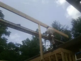 Carpenter setting a ridge beam over a new addition frame — Ice Dam Removal by Roofing Brothers in Pemberville