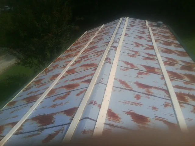 Rusted metal roof panels with new wood purlins before replacement — Storm Damage Roof Repair in Pemberville by Roofing Brothers